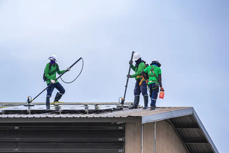 Roofing contractors from Sunstate Roofs applying energy-efficient roof coatings to a commercial property in Central Florida, extending roof life and reducing energy costs.