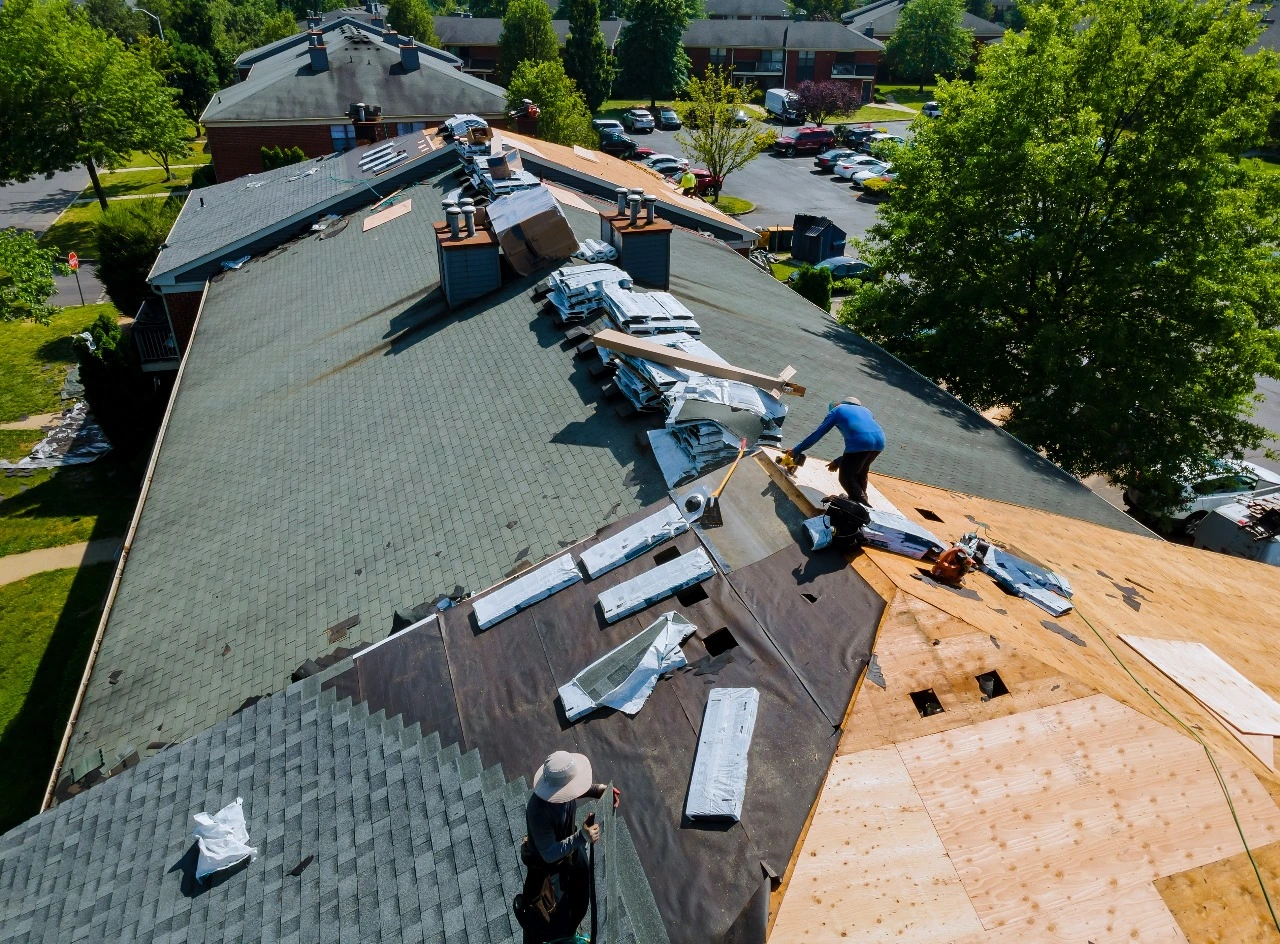 Roof replacement in progress on a residential property in Central Florida, featuring workers installing a shingle roof and preparing for metal roof installation. Keywords: roof replacement, Central Florida, shingle roof, roof installation, metal roof replacement, roof repair.