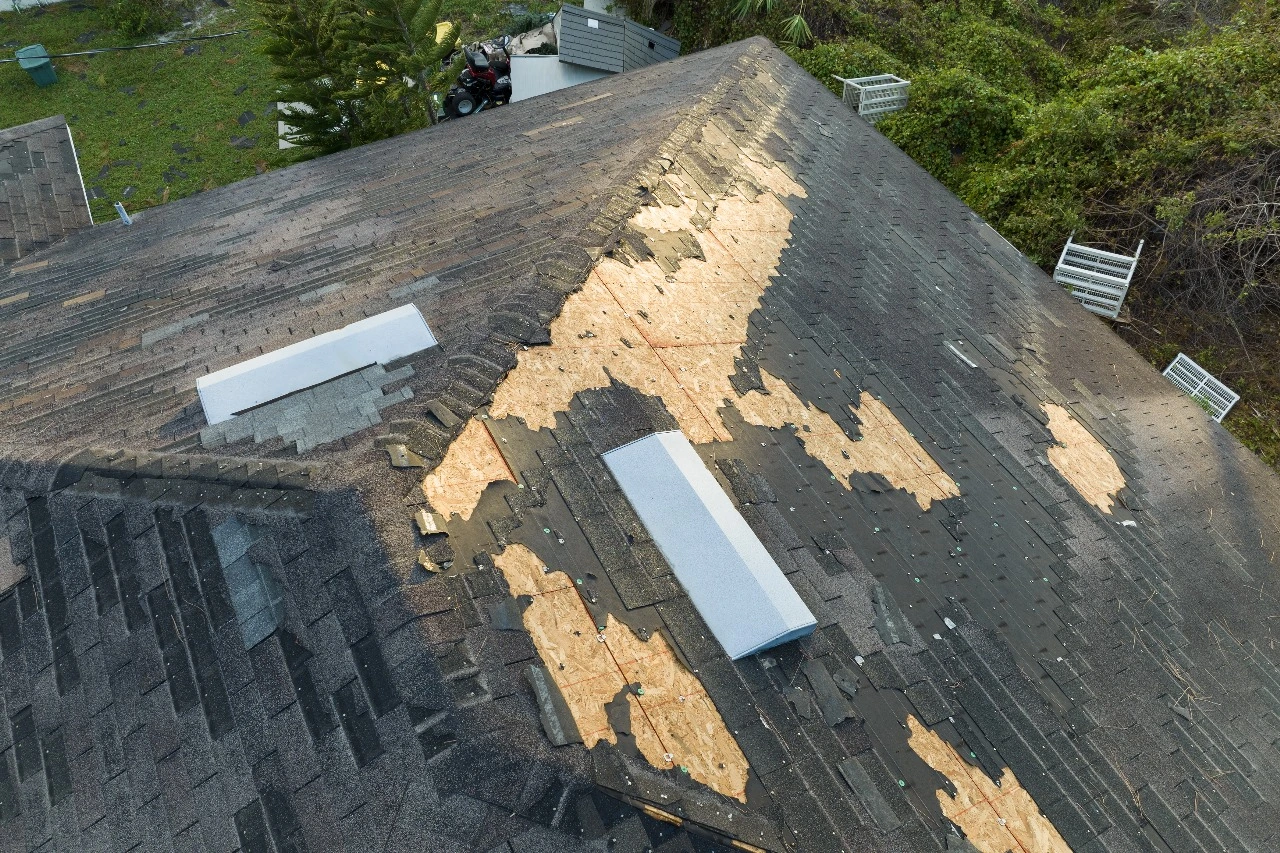 Image of a deteriorating roof in Central Florida showcasing visible damage, including missing and damaged shingles. Keywords: Replace your roof in Florida, roof replacement, State Certified Roofing Contractor in Orlando, Sunstate Roofs, roof inspection, aging roof, roof leaks, water damage, moss and algae growth, energy-efficient roof.