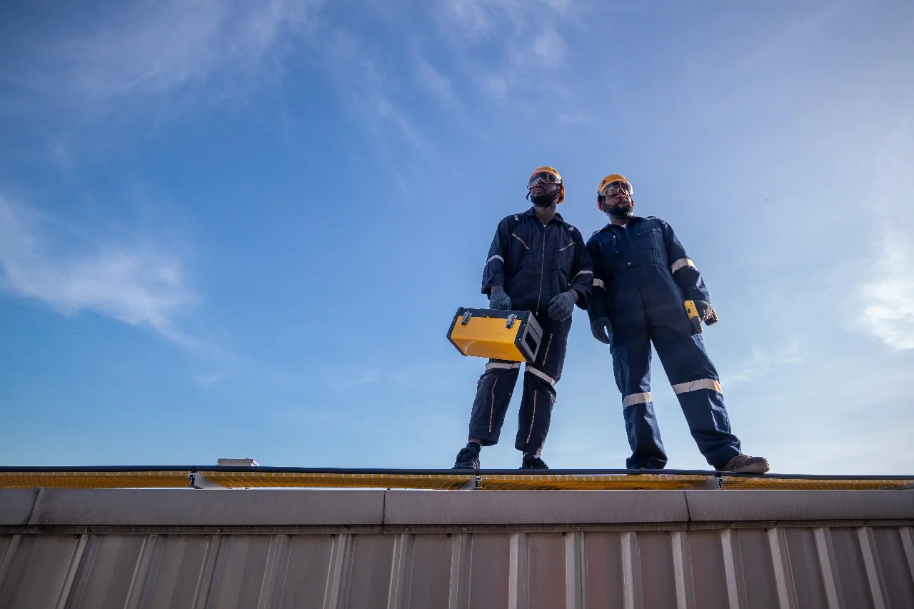 Two professional roofing contractors from Sunstate Roofs standing on a roof in Orlando, Florida, symbolizing expert roofing services. Keywords: cost to put a roof on in Orlando, roof replacement cost Orlando, roofing project Orlando, roofing materials cost, Orlando roofing contractor, Sunstate Roofs, Central Florida roofing.