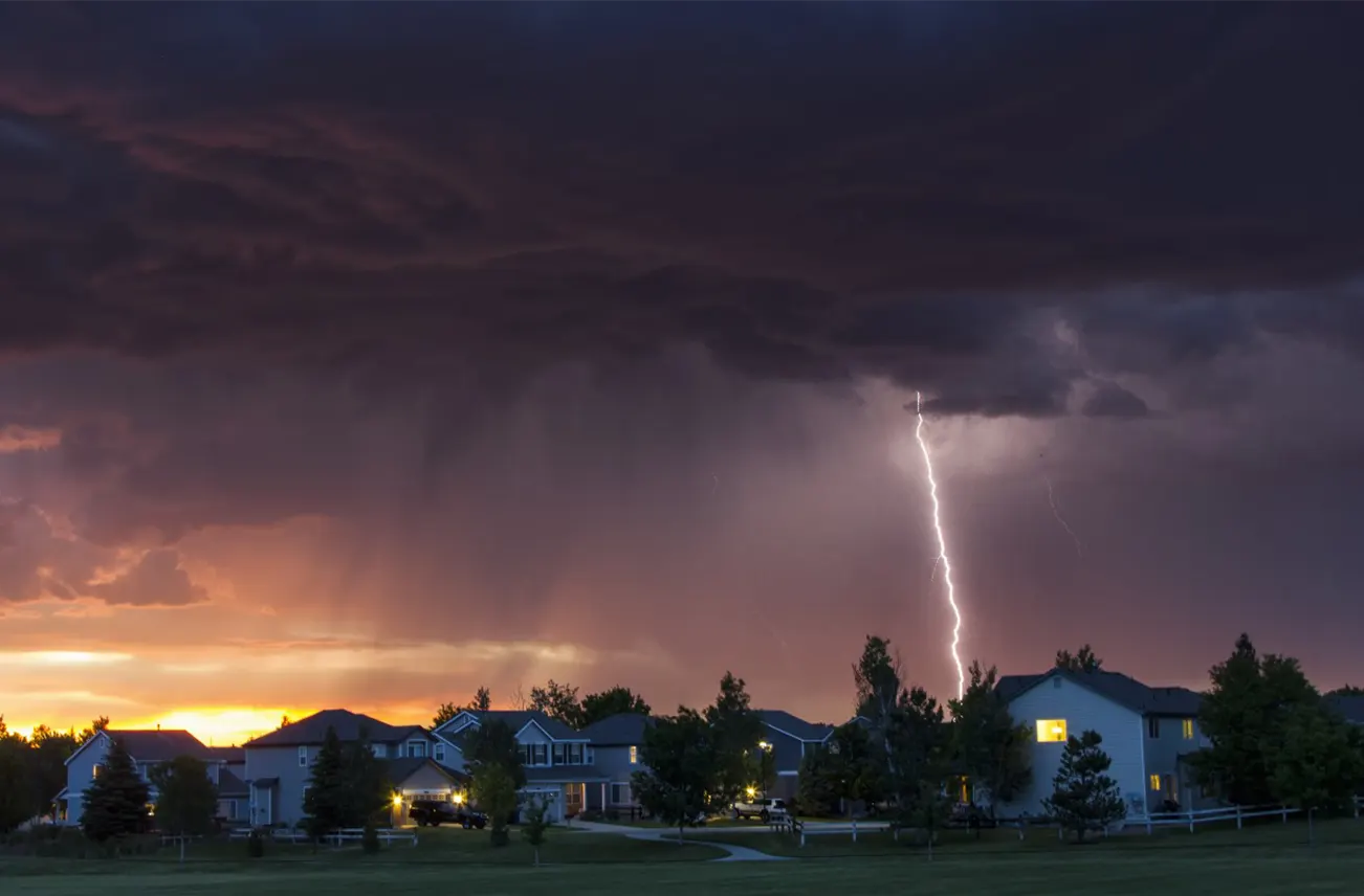 A dramatic storm with lightning striking near commercial buildings, highlighting Sunstate Roofs' expertise in storm-resistant commercial roof repairs in Central Florida. Sunstate Roofs provides reliable 'commercial roof repair near me,' offering competitive commercial roof repair costs and trusted contractors for safety and compliance.