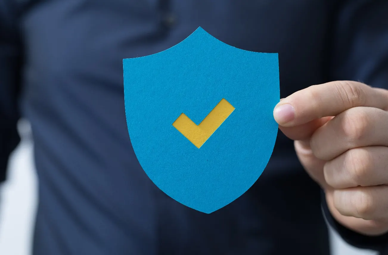 A professional holding a blue shield with a checkmark, symbolizing warranty protection for residential roofs in Central Florida. Sunstate Roofs provides trusted roof cleaning services, using advanced roof cleaning tools and solutions. Search 'roof cleaning near me' or 'roof cleaning services near central florida' for expert care.