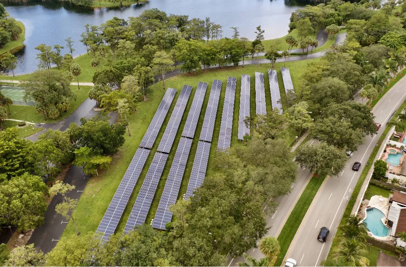 Aerial view of solar panels surrounded by lush greenery in Central Florida, showcasing sustainable energy solutions. Sunstate Roofs offers residential services, including Roof Replacement cost analysis, relief services, tape solutions for repairs, and nearby replacement services.