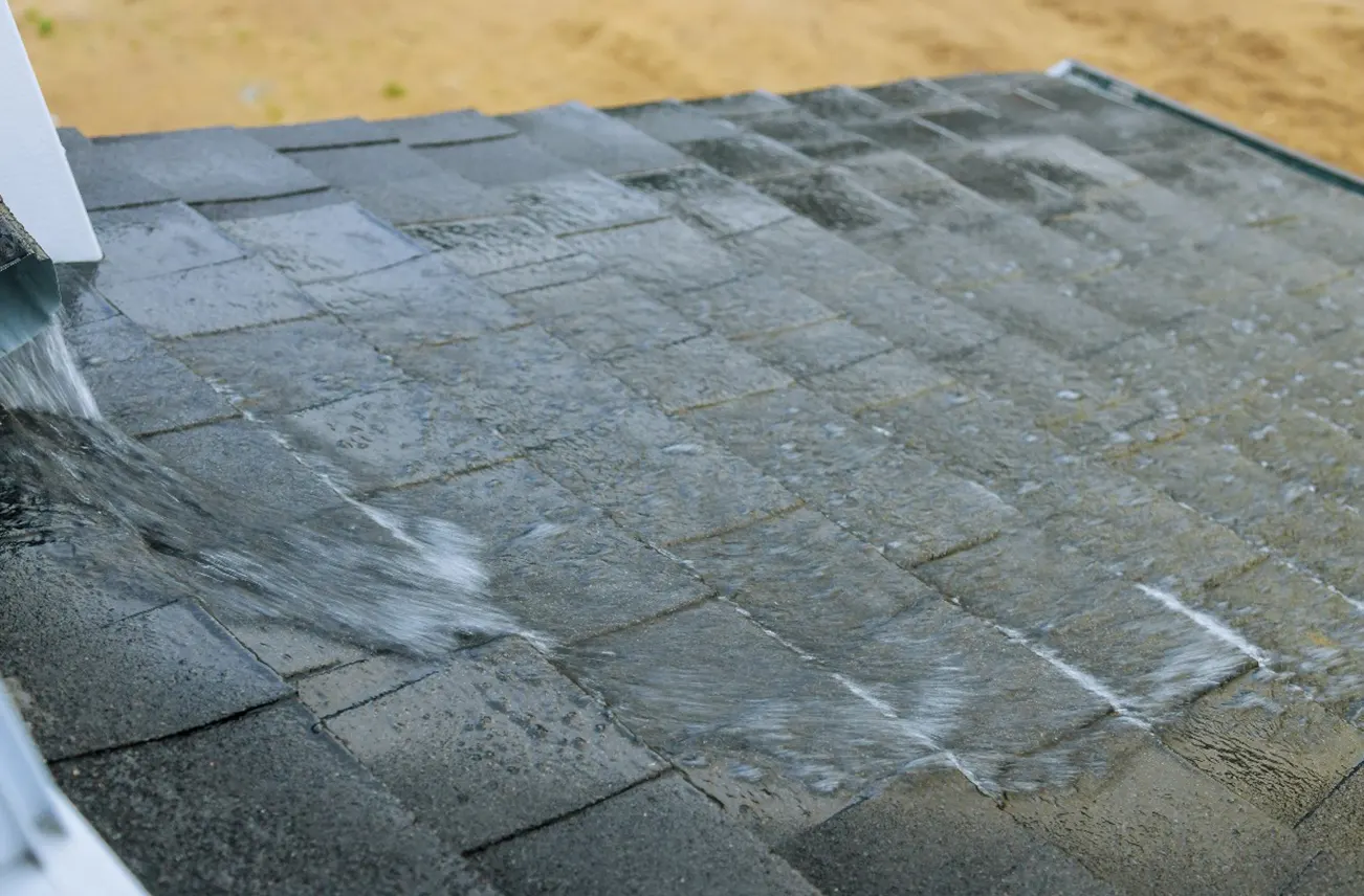 Close-up of a residential roof with water running off, highlighting Sunstate Roofs' expert leak repair services in Central Florida. For reliable 'residential roof repair near central florida' or 'residential roof repair Orlando,' Sunstate Roofs provides thorough inspections and water damage prevention solutions.