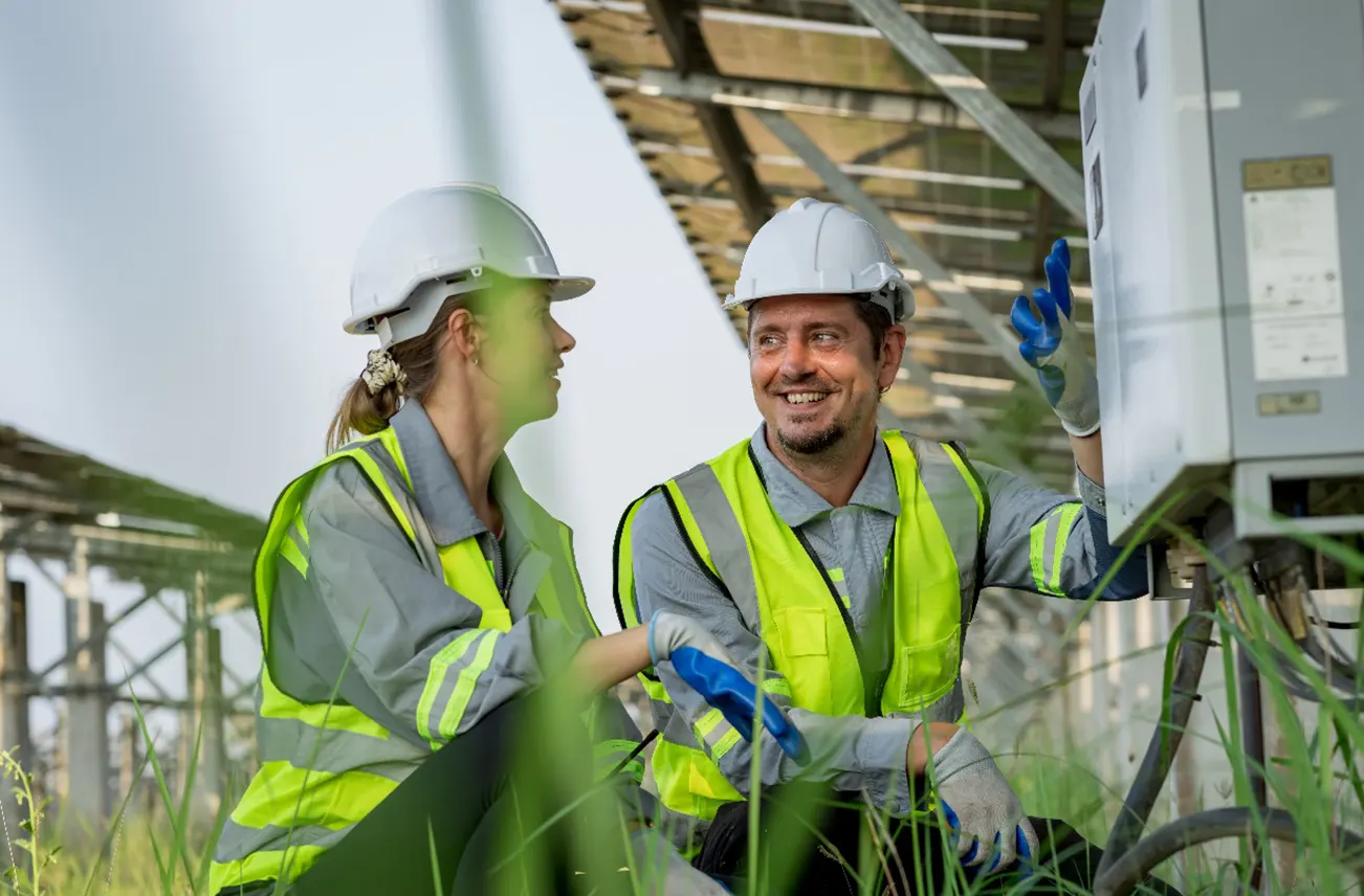 Two construction professionals inspecting a commercial roofing project under a solar panel structure in Central Florida, showcasing Sunstate Roofs' sustainable commercial services. Sunstate Roofs offers competitive commercial roof replacement costs, tax benefits, and trusted commercial roof replacement near central florida solutions.