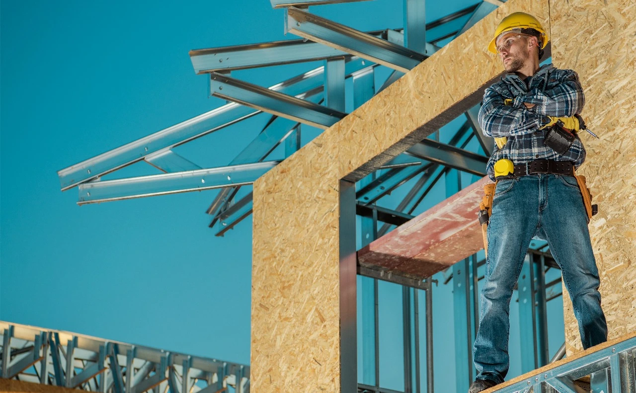 Construction professional representing Sunstate Roofs in Baldwin Park, FL, standing confidently near a building structure. Highlighting expertise in roof inspections, repairs, replacements, and maintenance. Trusted roofing contractor offering tailored roofing solutions for Baldwin Park homeowners