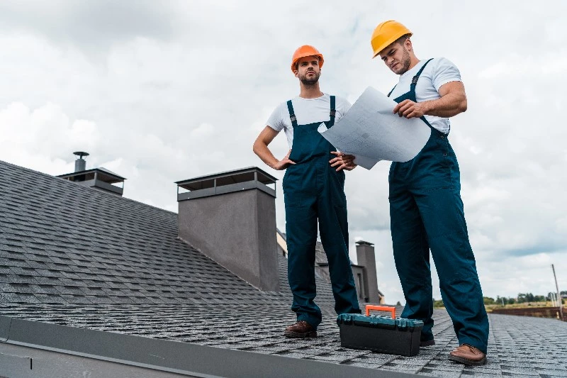 Two certified roofing contractors reviewing roof installation plans on a residential roof in Central Florida, representing expert roofing services, including roof repairs, replacements, inspections, maintenance, and storm-ready installations, provided by a trusted certified roofing contractor specializing in Central Florida roofing needs.