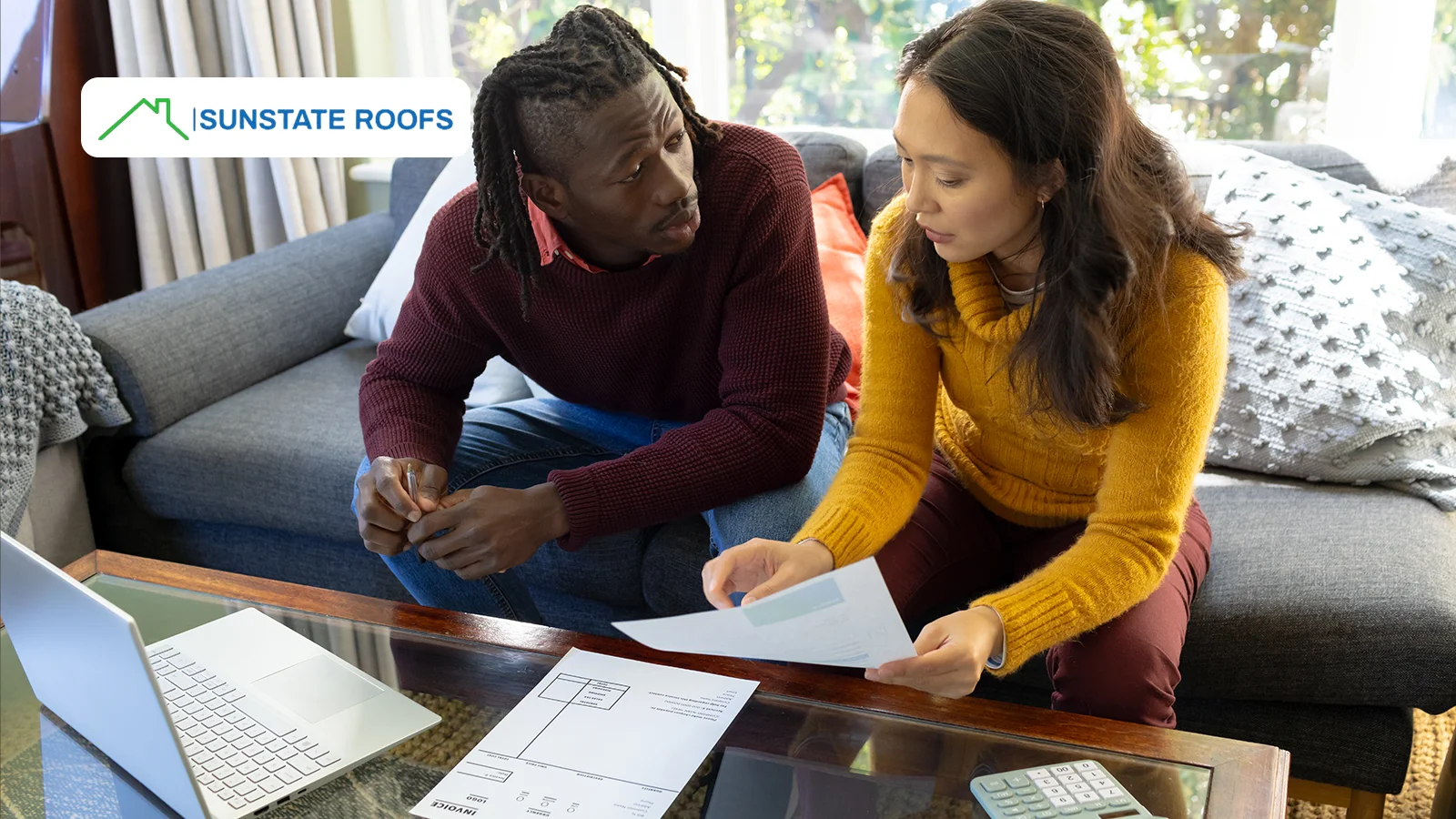 A couple reviewing bills and discussing affordable roof repairs to protect their home from escalating costs.