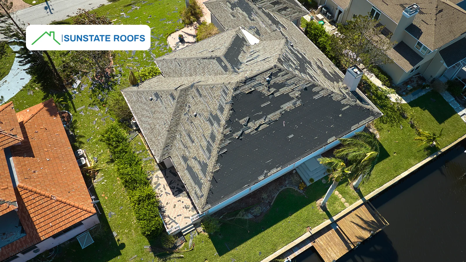 An aerial view of a storm-damaged roof, illustrating the consequences of neglecting roof repairs in areas prone to severe weather.