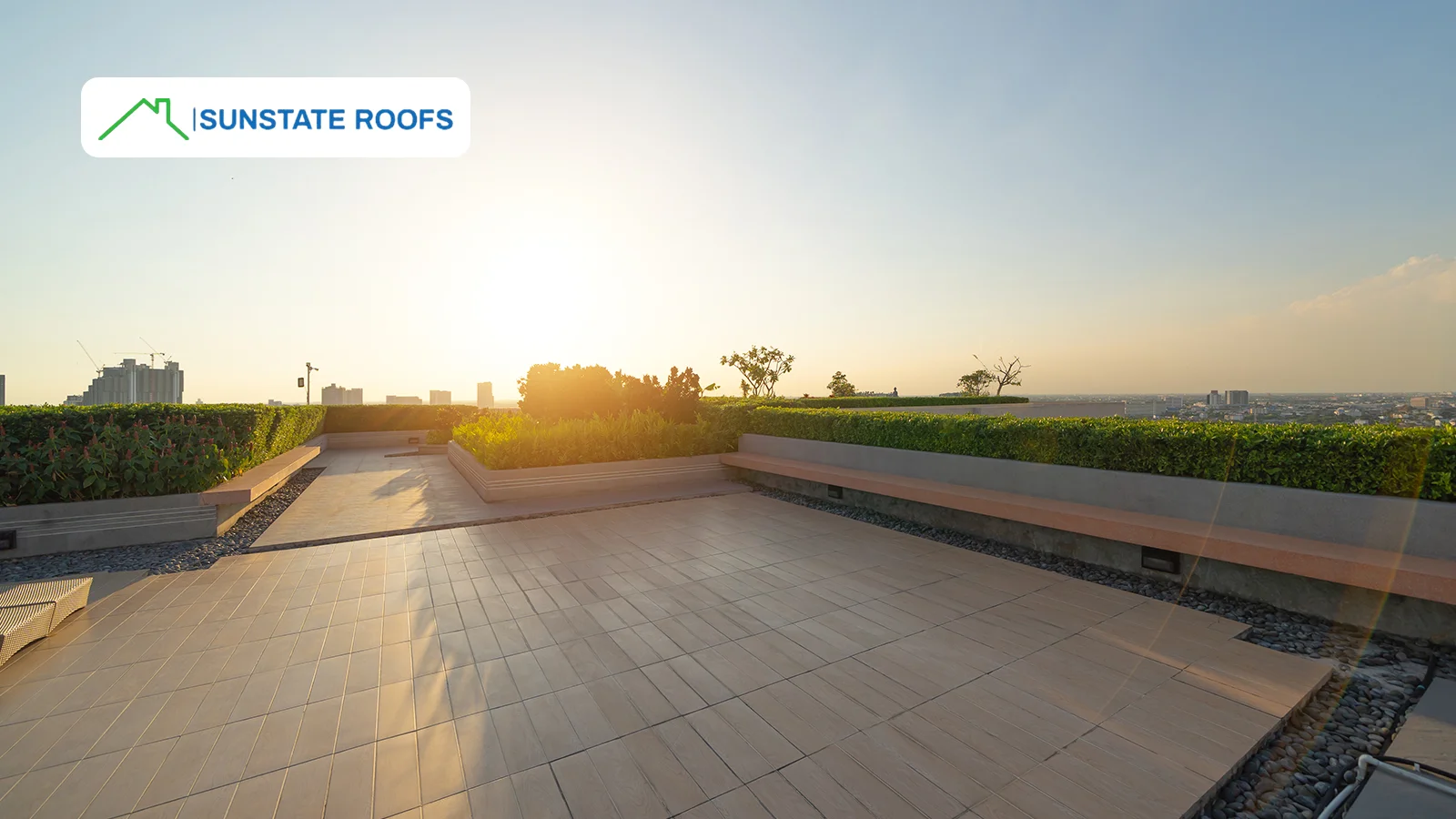  A modern flat rooftop with garden and with a stunning city view, illustrating how residential roofing can enhance outdoor living spaces.