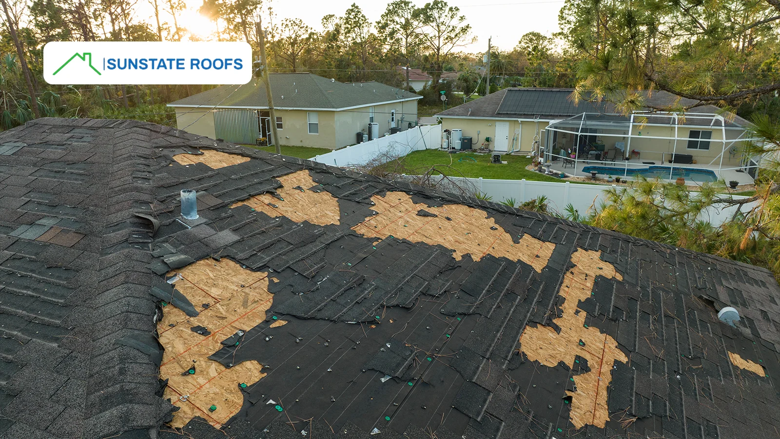 Severely damaged asphalt shingles on a residential roof, highlighting the importance of timely roof repairs after storms.