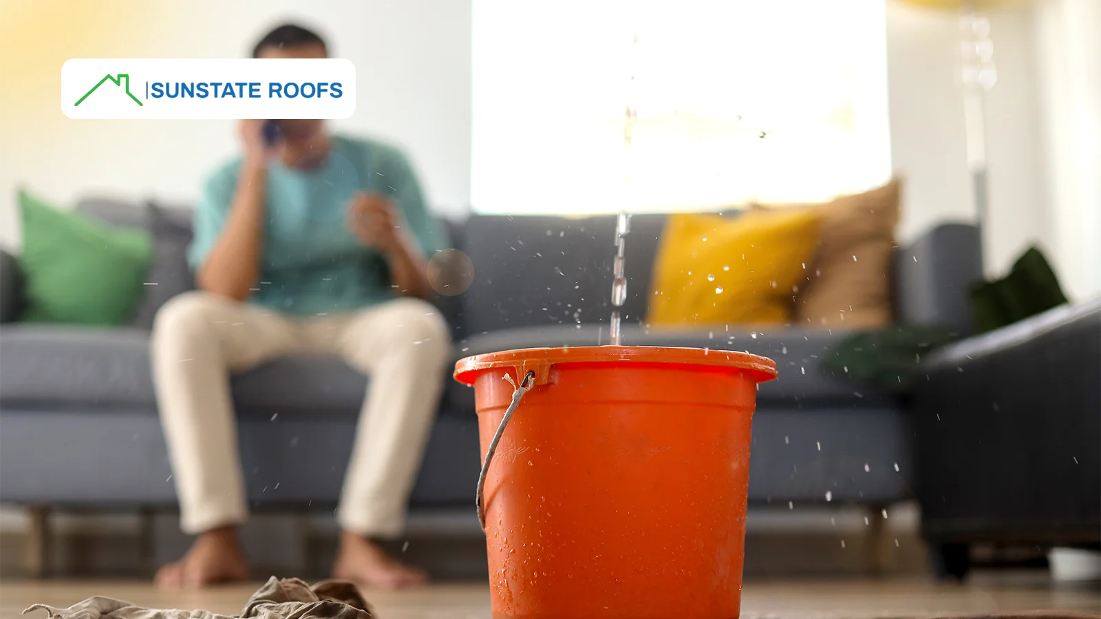 A bucket collecting water from a ceiling leak, emphasizing the urgency of fixing roof leaks to prevent further home damage.