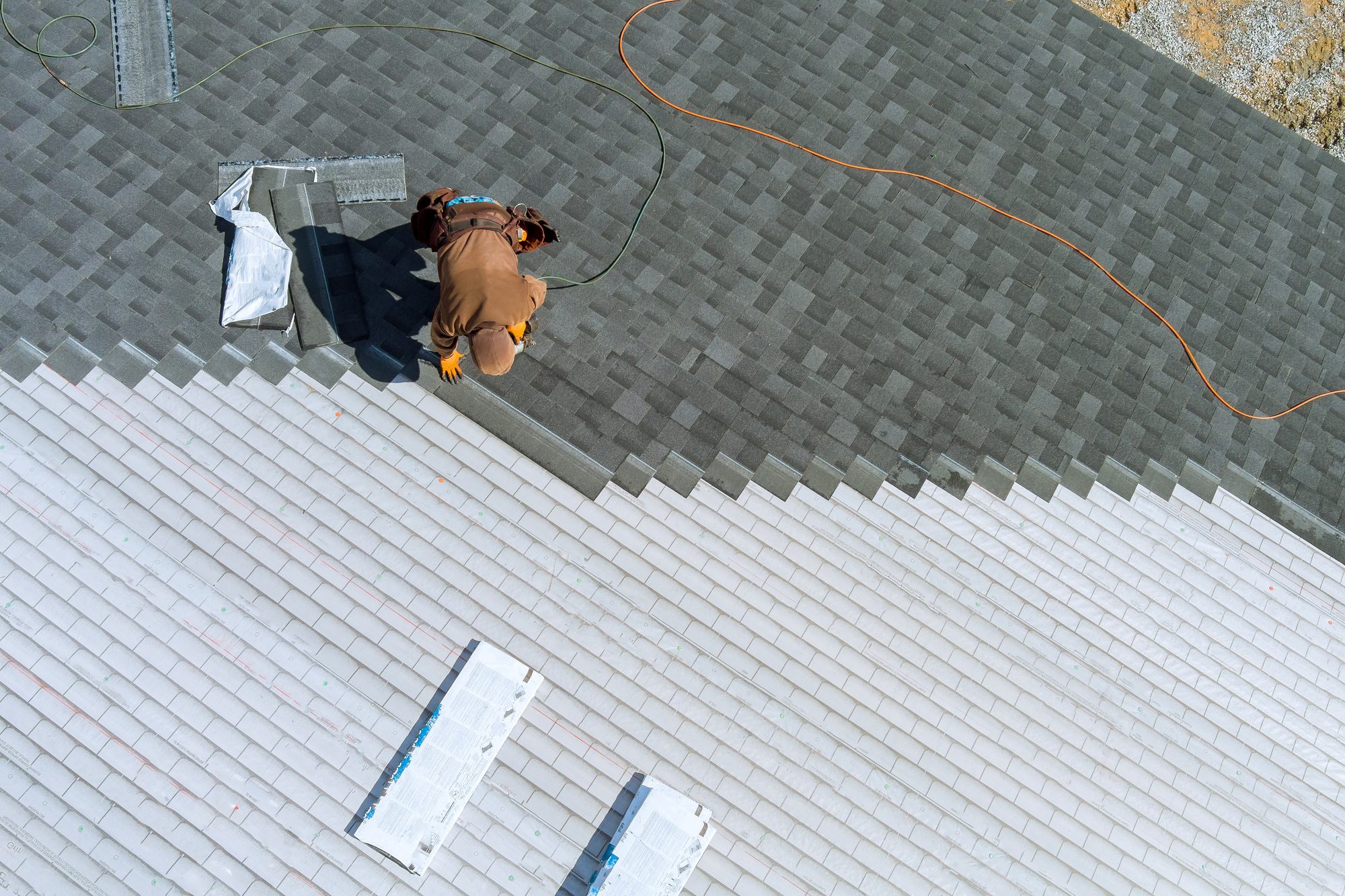 skilled roofers in College Park installing shingles on the roof of a home.