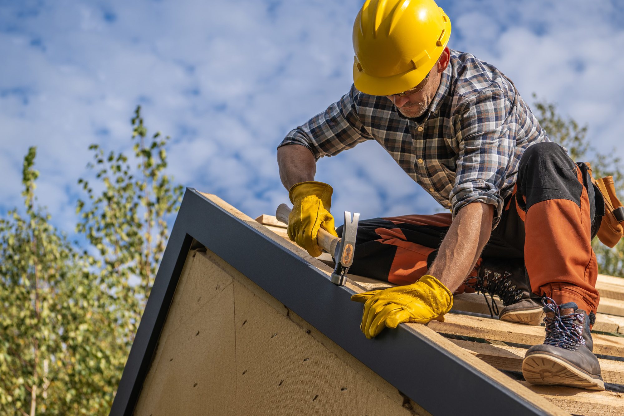 Caucasian professional roof contractor inspecting a residential roof, offering services with Acorn Finance Solutions for affordable payment plans.