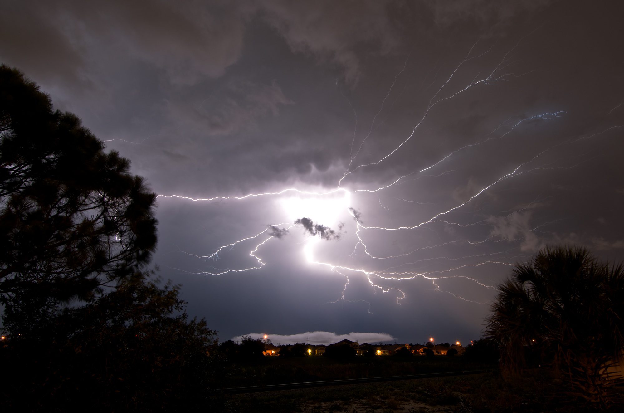 A powerful lightning strike spreads across the sky like a spider web in Rockledge, Florida. This highlights the importance of Roof Replacement in Winter Park to protect homes from storm damage.