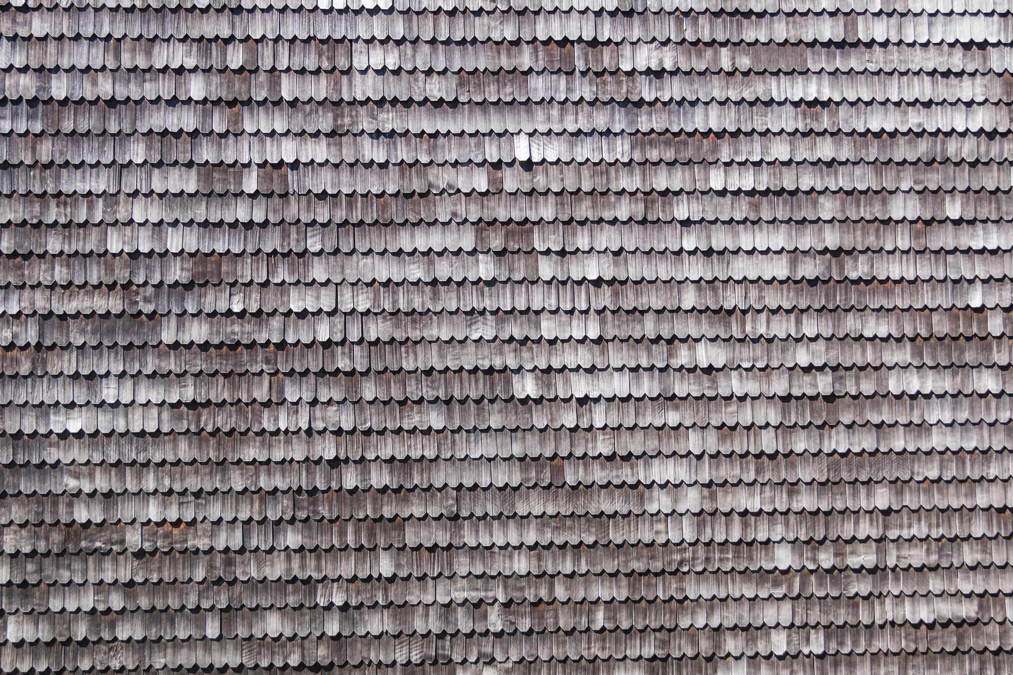 Close-up of wooden shingles on a traditional building in Chiloé Island, Chile, showcasing the durability and aesthetic appeal of Architectural Shingles as a premium roofing solution.
