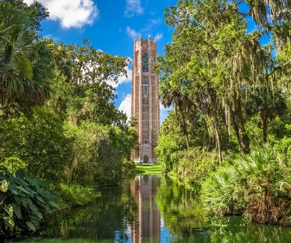 A scenic view of Bok Tower Gardens in Winter Park, FL, surrounded by lush greenery and a reflective pond, showcasing the charm of Central Florida. Sunstate Roofs, a trusted roofing company and contractor, provides expert residential roofing and commercial roofing services in Winter Park